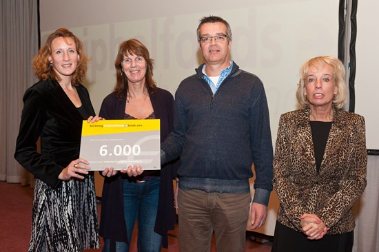 Hester, Tink en Arjen nemen de cheque in otvangst