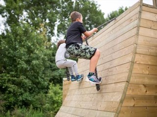 kinderen beklimmen quarterpipe